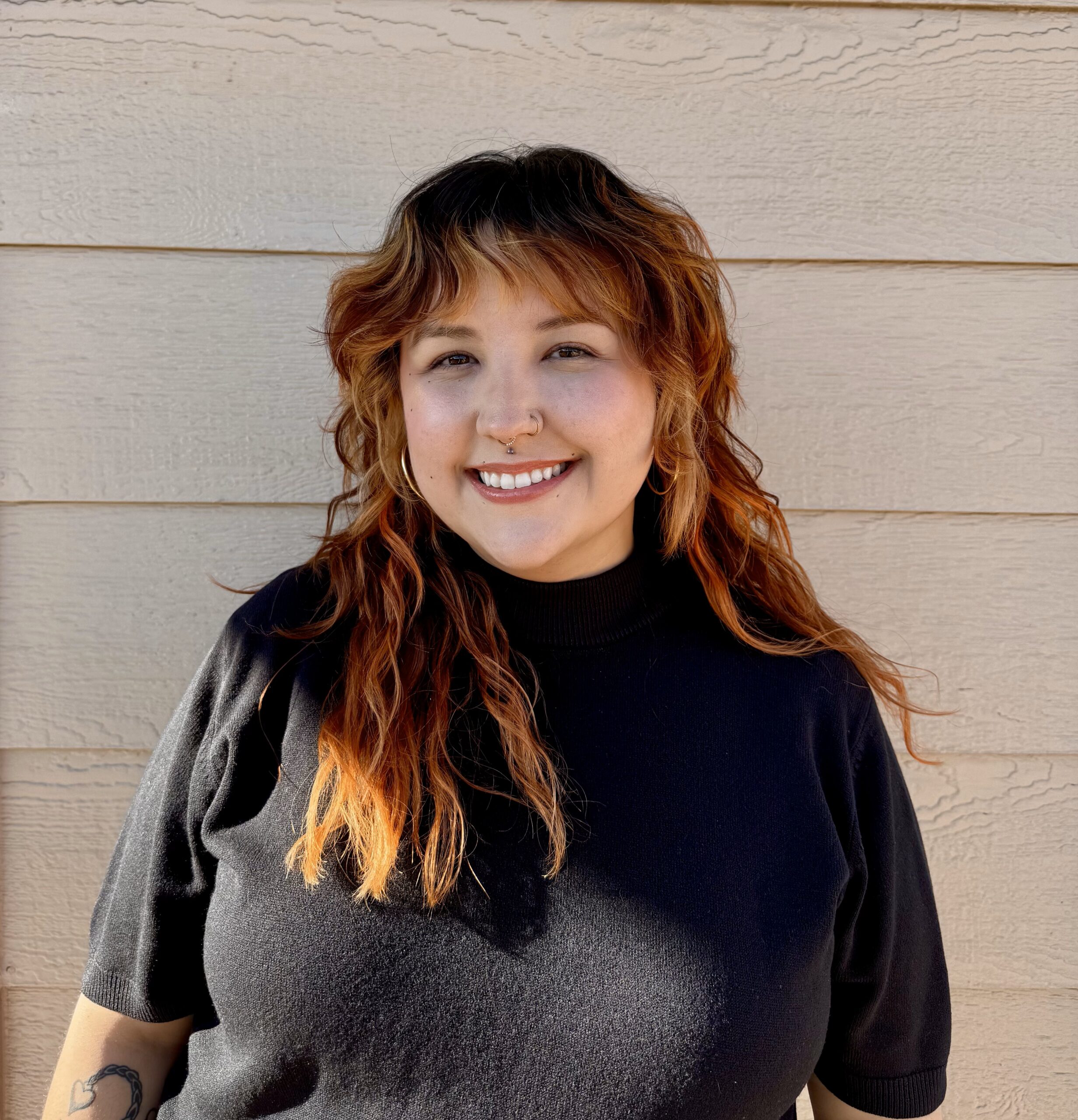 Headshot photo of Kassandra, smiling, in front of a light background