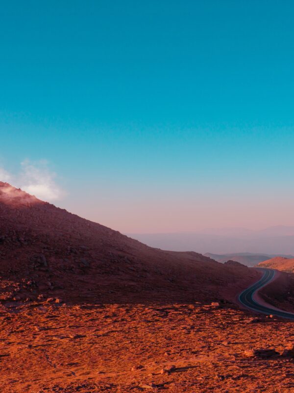 Photo of red hills next to a road