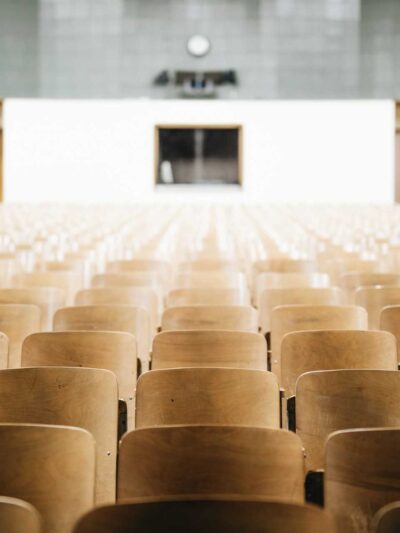 Photo of an empty auditorium with wooden seats