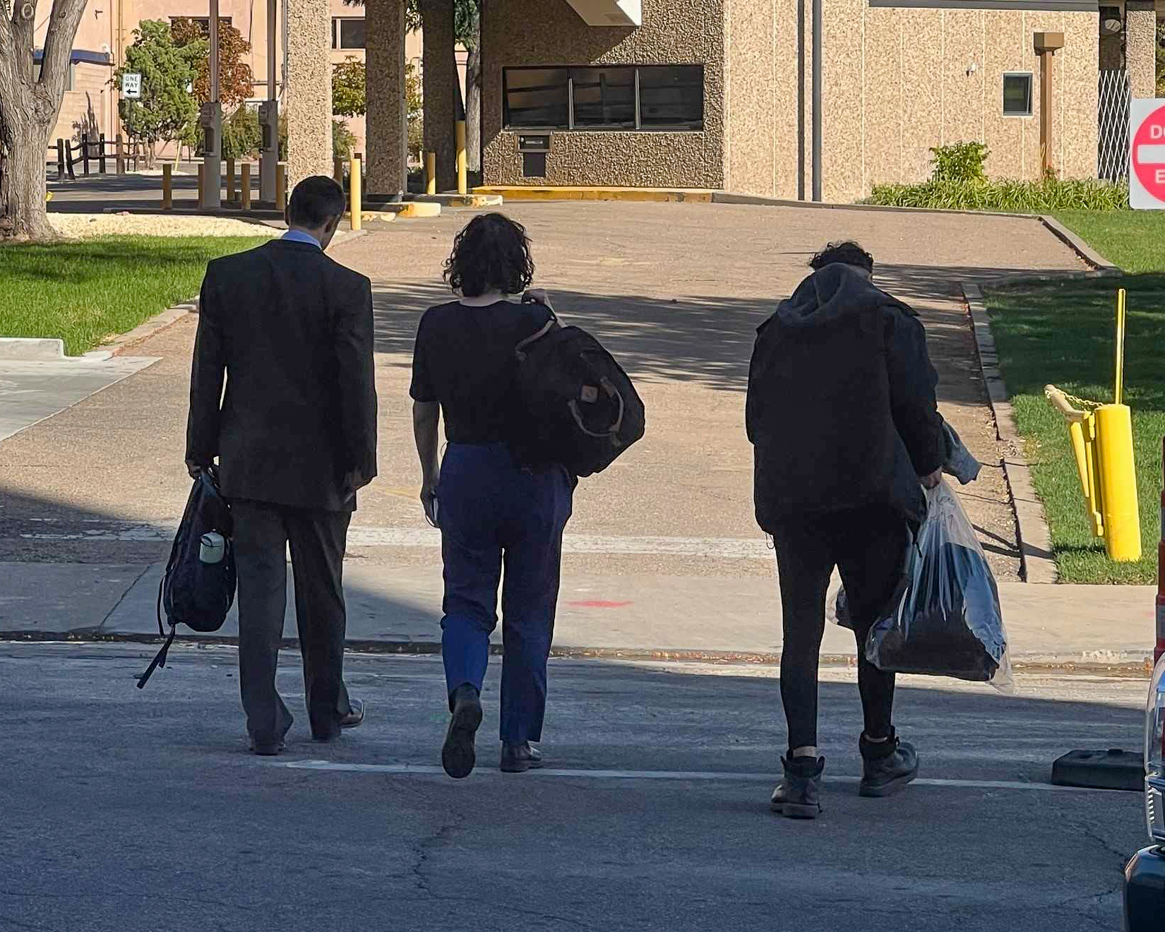 Photo of Dean Lopez and his two attorneys from behind, walking away
