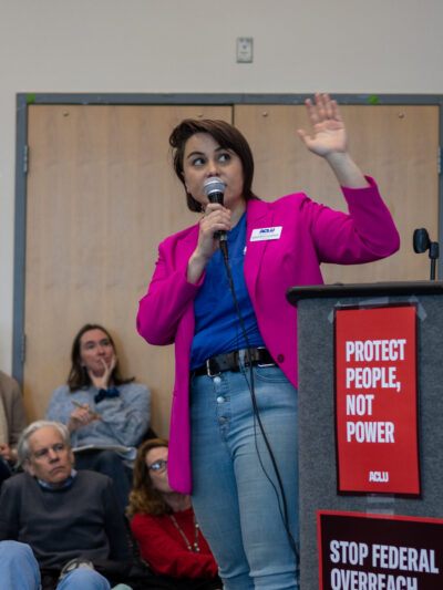 ACLU of Colorado director of advocacy speaking on a microphone at an activist event