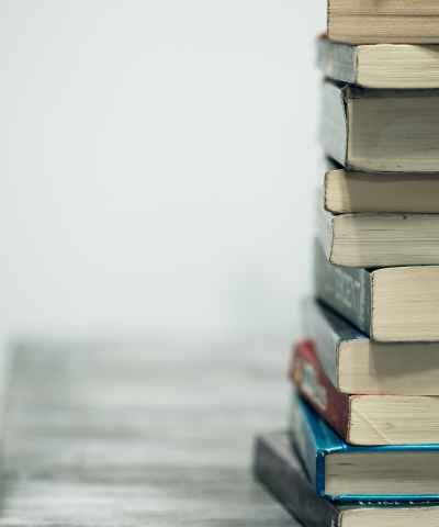 A stack of books on a table against a gray background