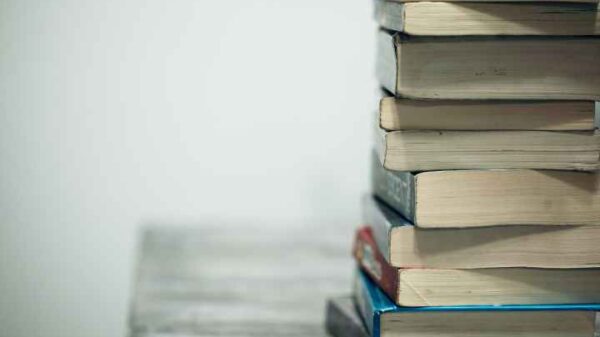 A stack of books on a table against a gray background