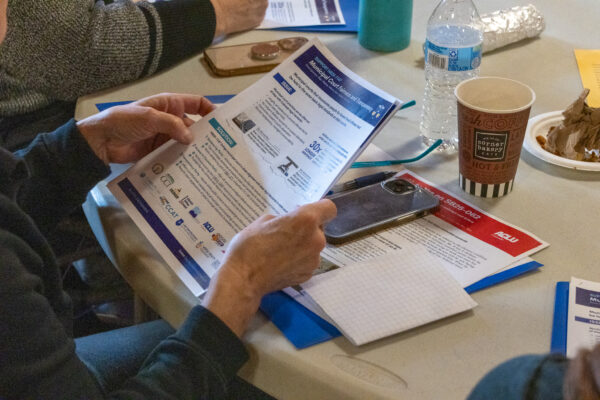 Photo of a person holding pages of printed resources