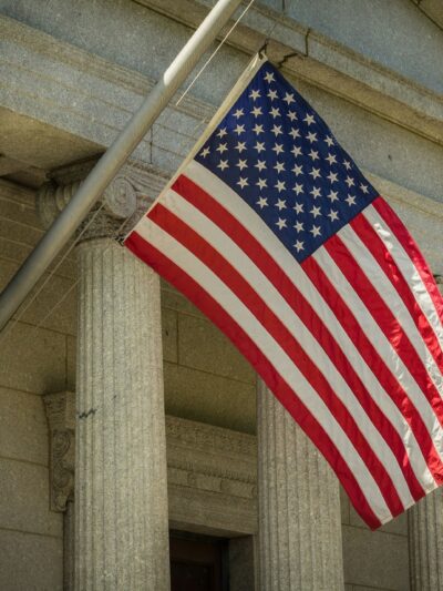 US flag hanging form the pillars of a courthouse