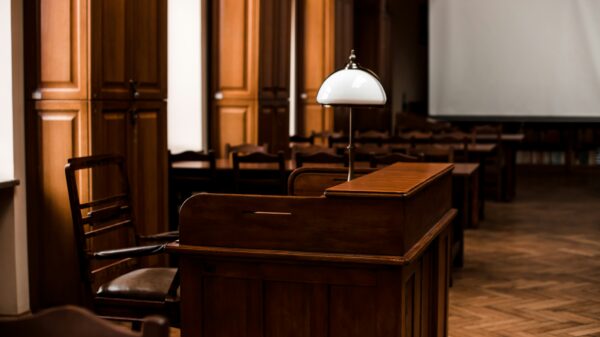 Photo of a desk with a lamp on top inside a court room