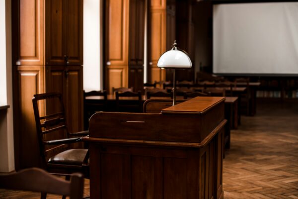 Photo of a desk with a lamp on top inside a court room