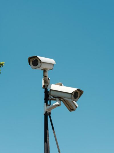 Photo of 3 CCTV cameras on a pole with a blue sky in the background.