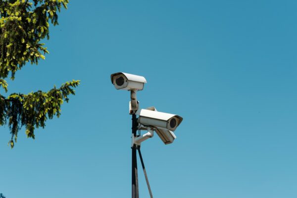 Photo of 3 CCTV cameras on a pole with a blue sky in the background.