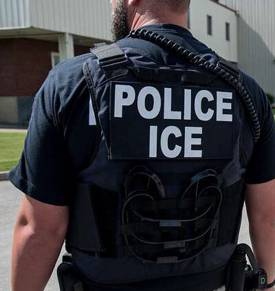 Photo of a law enforcement officer with the words police ice written on the back of a vest