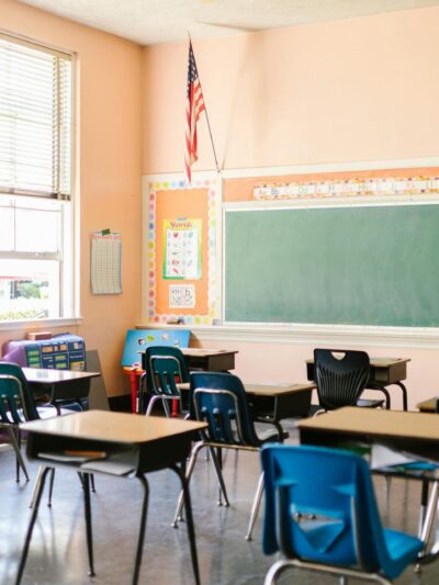 A US flag hangs from the wall in a classroom.