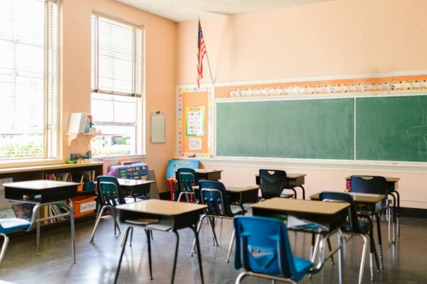 A US flag hangs from the wall in a classroom.