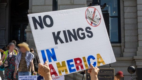 Protestor holding sign with text saying No Kings in America