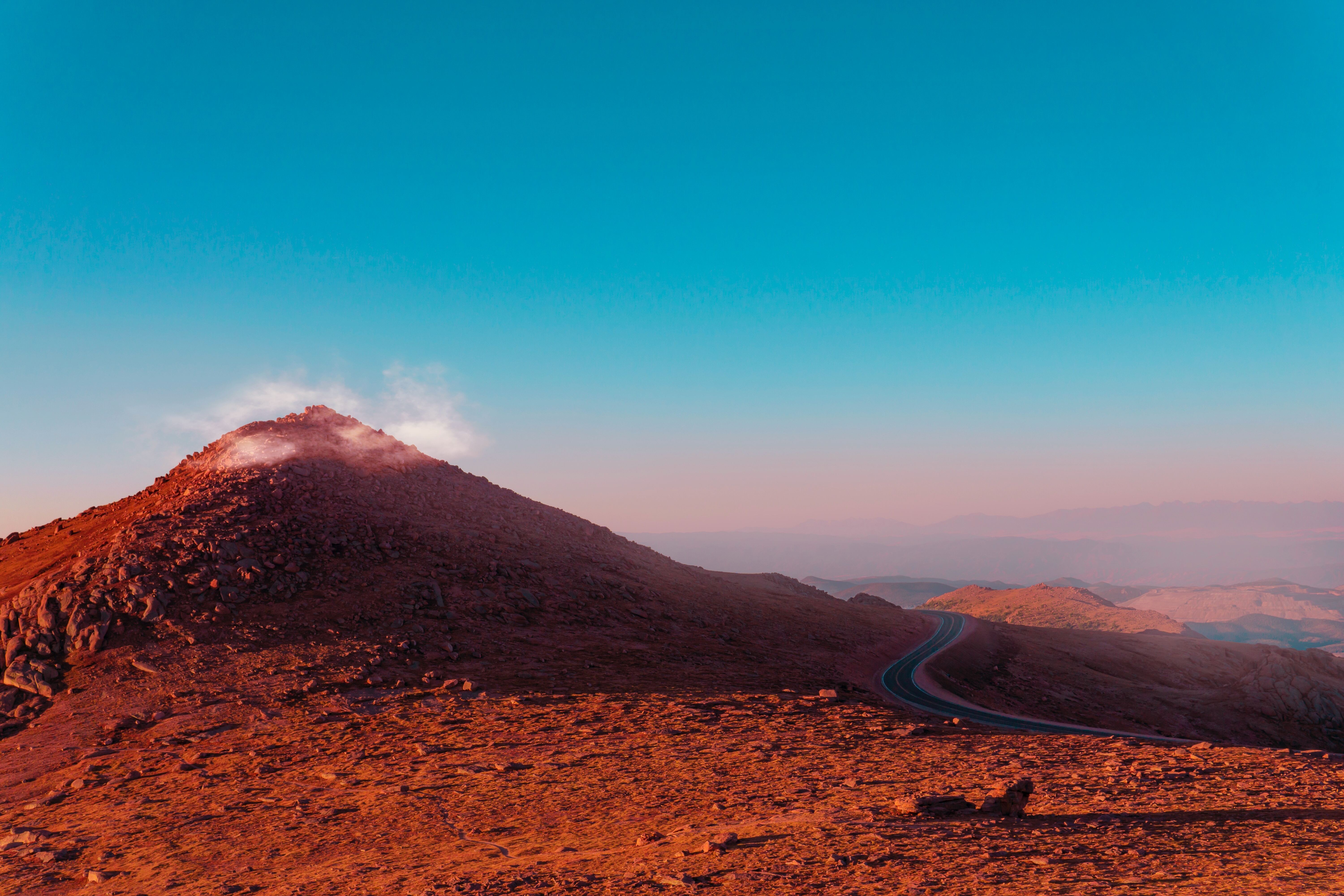 Photo of red hills next to a road