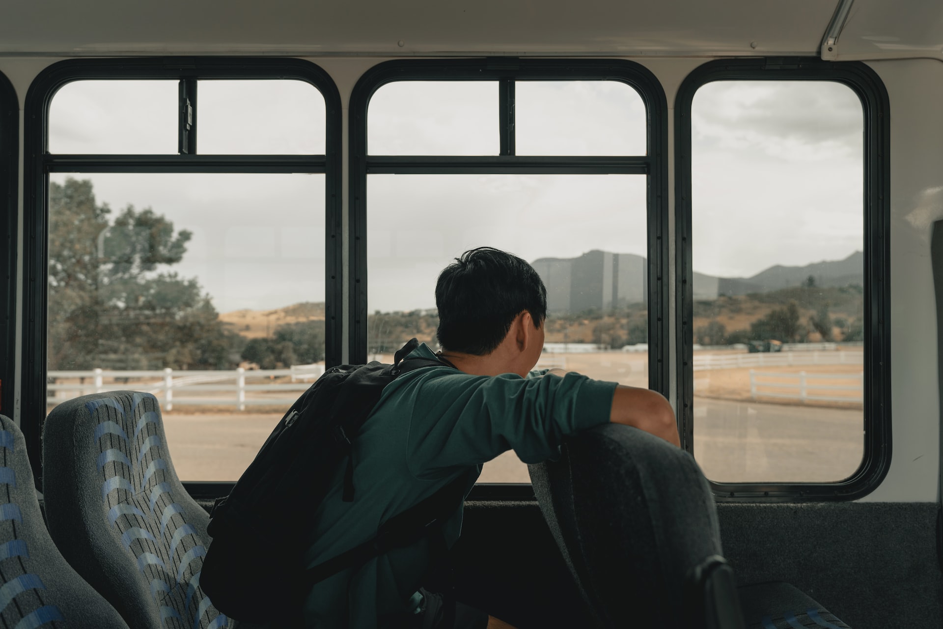 A child with a backpack rides a bus