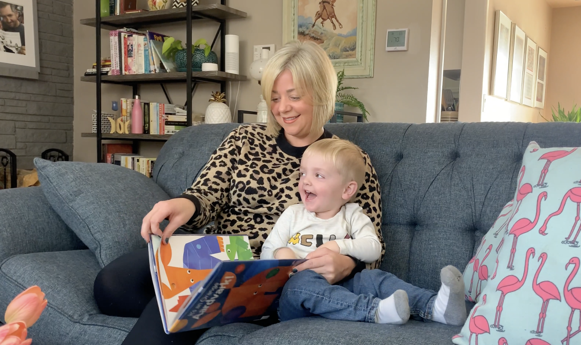 Melissa Hodgkins, flight attendant for Frontier Airlines, reading a children's book with her child