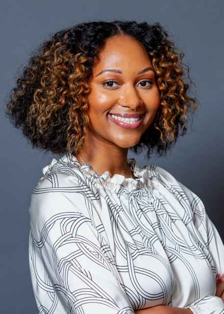 Rebecca Bowman headshot, smiling, in front of gray background
