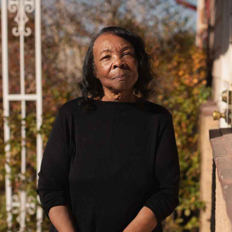 Photograph of Ruby Johnson sitting on her porch on a sunny day