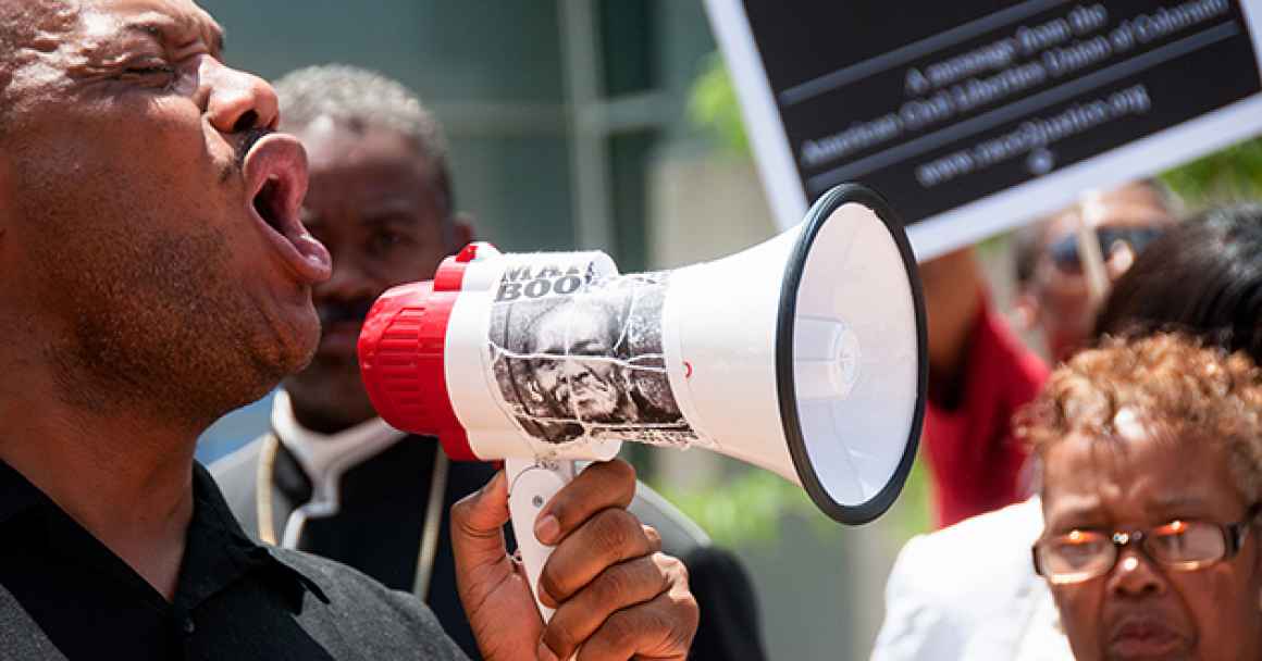 A man with a megaphone at a protest for racial justice