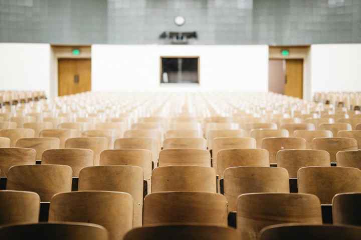Photo of an empty auditorium with wooden seats