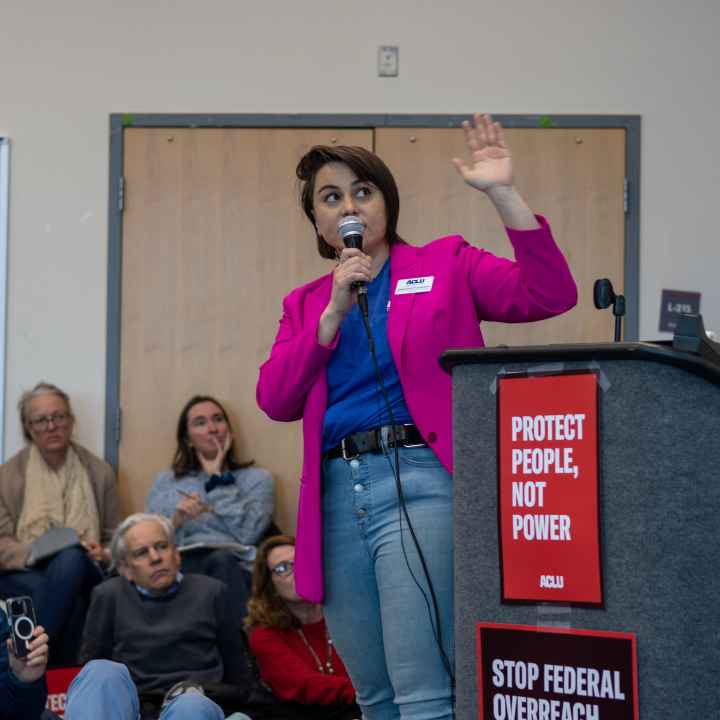 ACLU of Colorado director of advocacy speaking on a microphone at an activist event