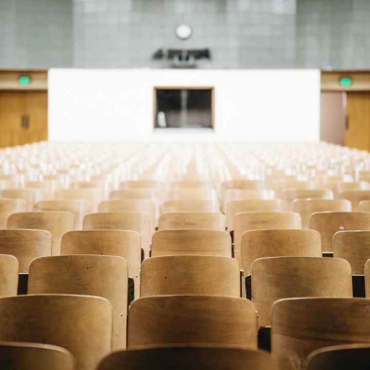 Photo of an empty auditorium with wooden seats